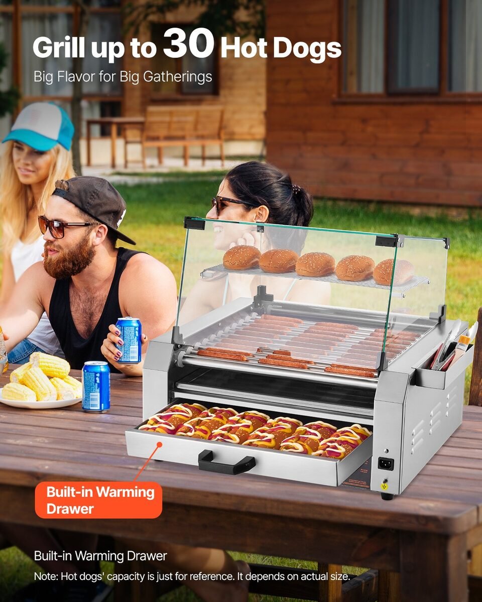 Roler za hrenovke pod staklenom kupolom na stolu na zabavi u dvorištu, gosti jedu hot dog